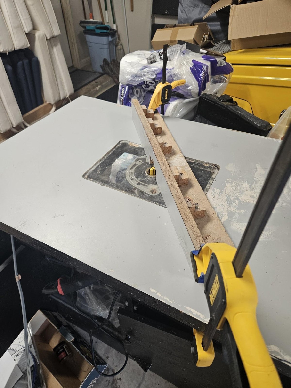 A router table with a straight wooden fence clamped across it, set up to cut a rabbet