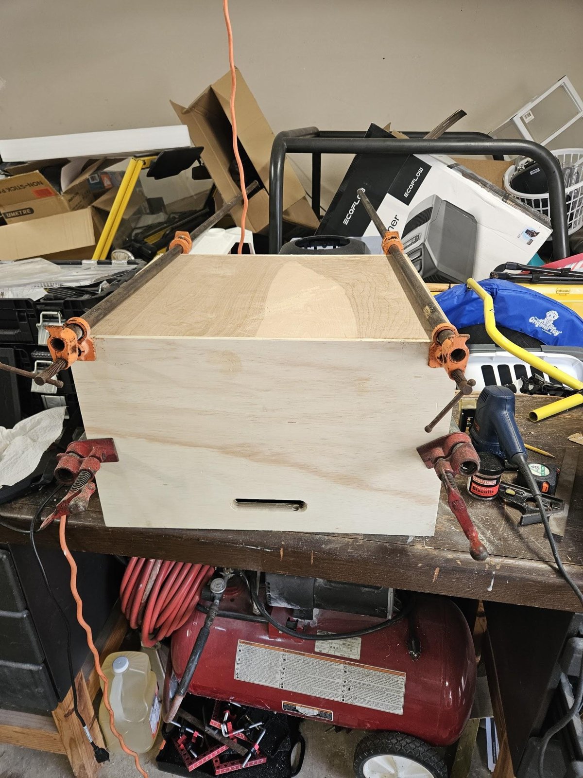 The plywood drawer box glued up on the bench, held in pipe clamps and bar clamps
