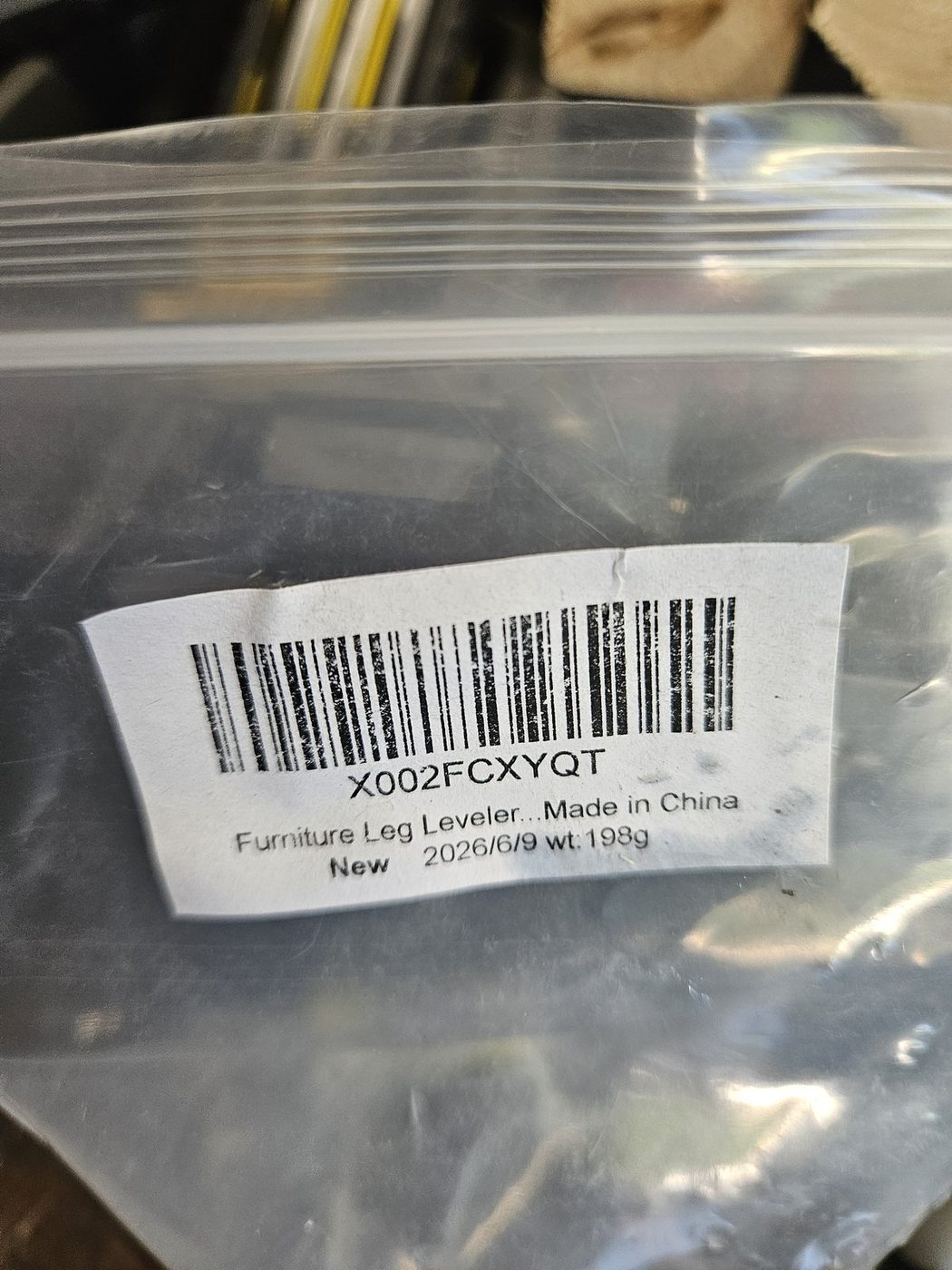 The packaging label from the adjustable furniture leveler feet used on the build